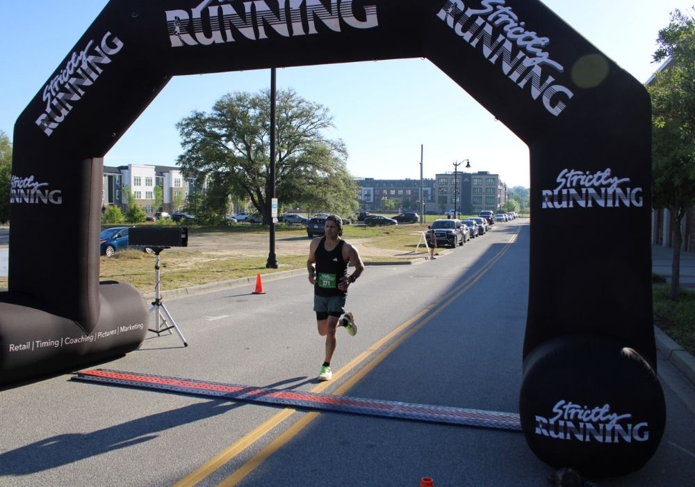 Man runner crossing finish line — 2026 Strides for Autism