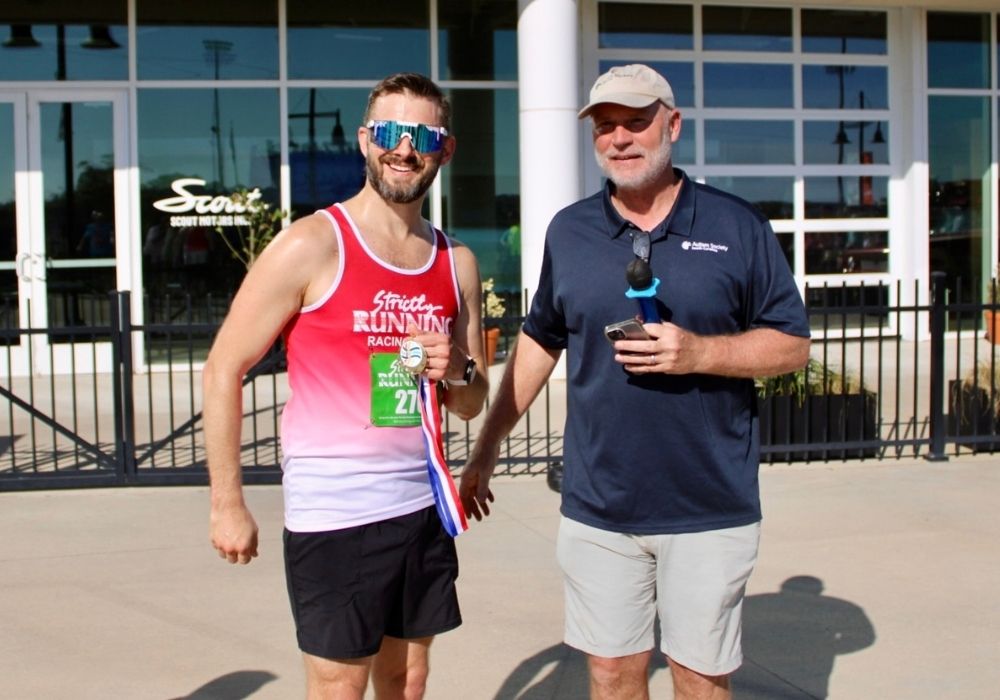 Participant holding medal posing — 2026 Strides for Autism