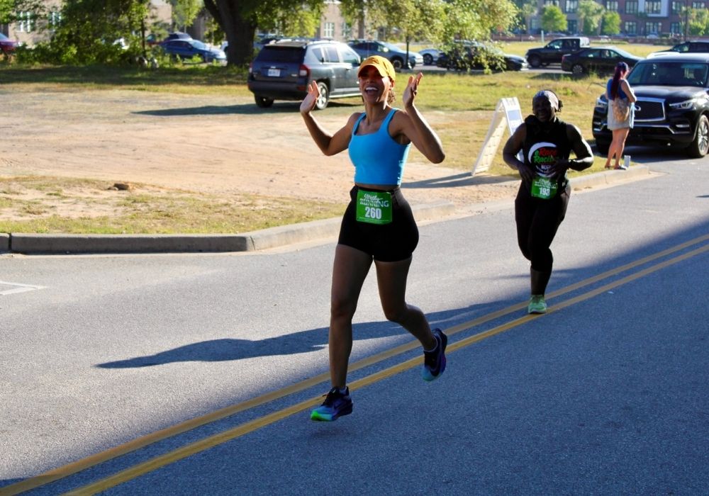 Runner arms raised finish — 2026 Strides for Autism