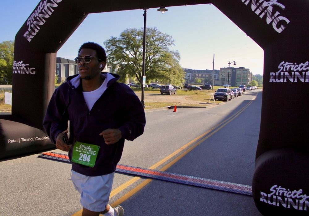 Runner crosses finish line — 2026 Strides for Autism
